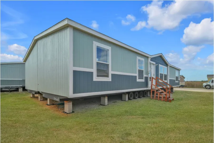 A mobile home is sitting on top of a lush green field.