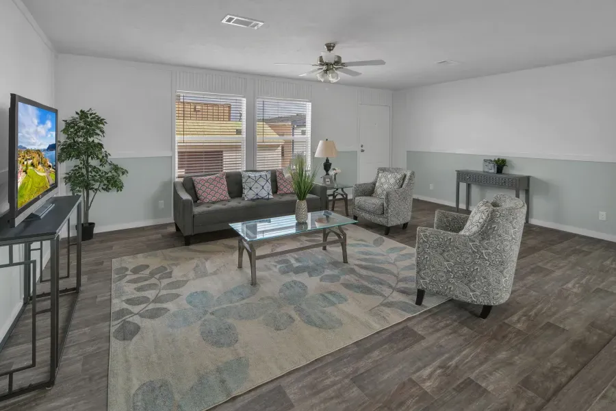 A living room with a couch , chairs , coffee table and television.