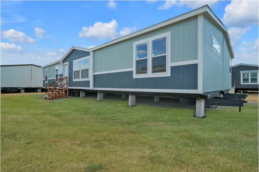 A mobile home is sitting on top of a lush green field.