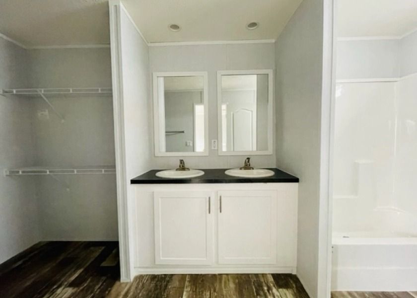A bathroom with two sinks and two mirrors.