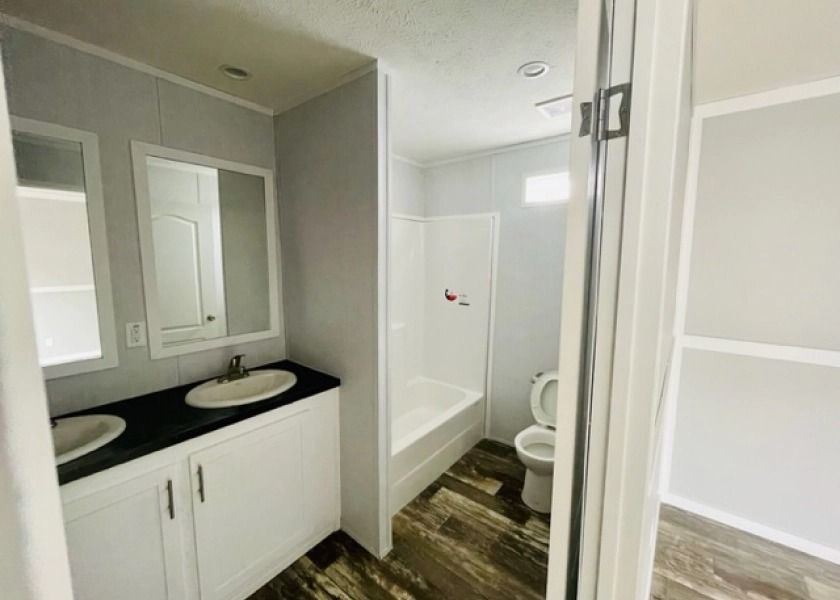A bathroom with two sinks , a toilet , and a shower.