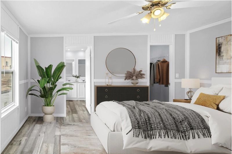 A bedroom with a bed , dresser , mirror and ceiling fan.