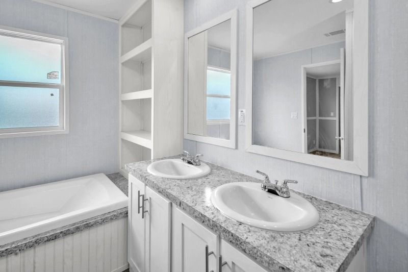 A bathroom with two sinks , two mirrors and a tub.