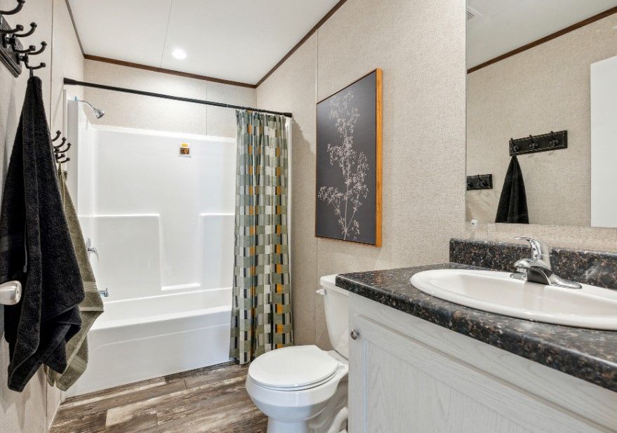 A bathroom with a toilet , sink , and bathtub.