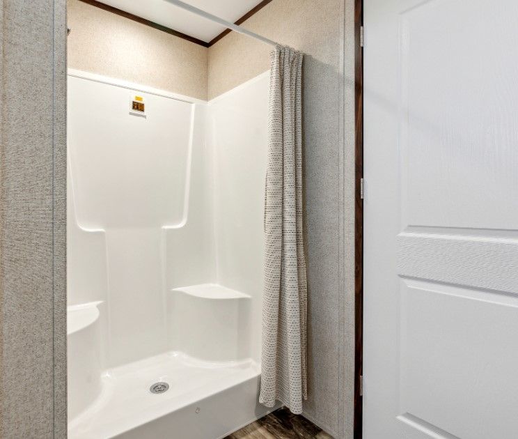 A bathroom with a shower stall and a shower curtain.