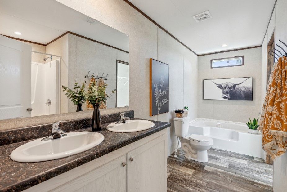 A bathroom with two sinks , a toilet , and a bathtub.