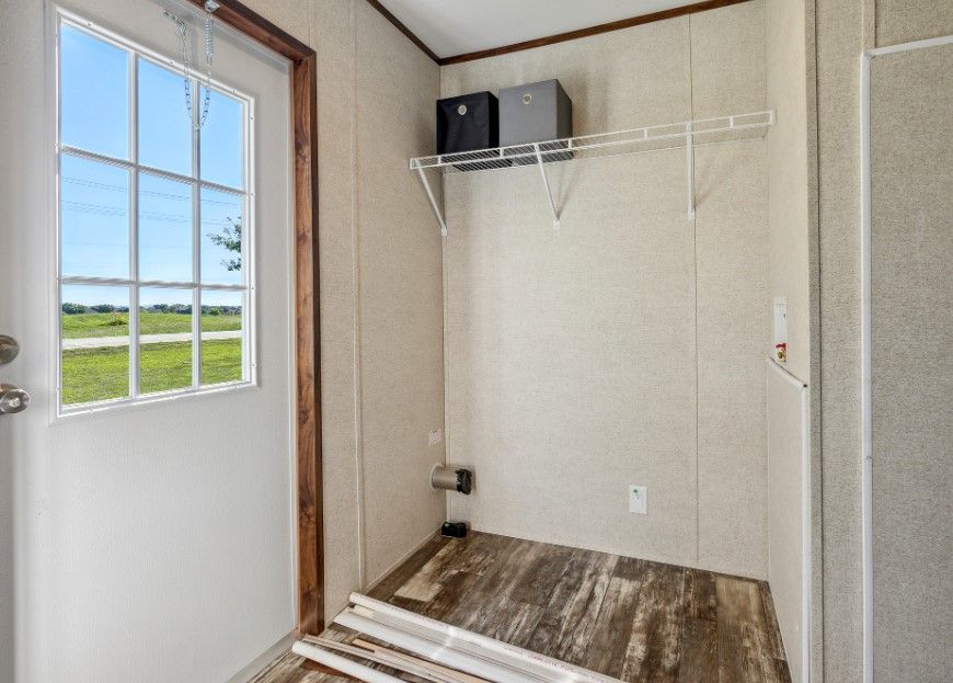 A laundry room in a mobile home with a door and a window.