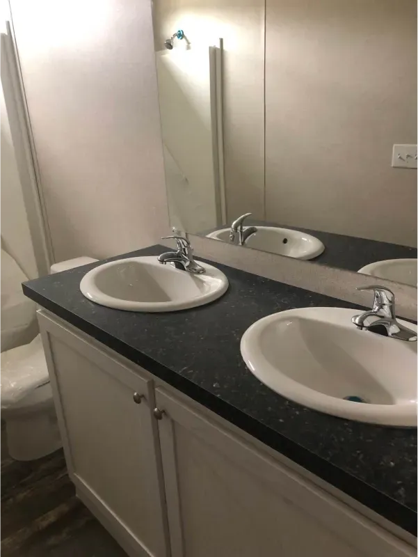 A bathroom with two sinks and a toilet.