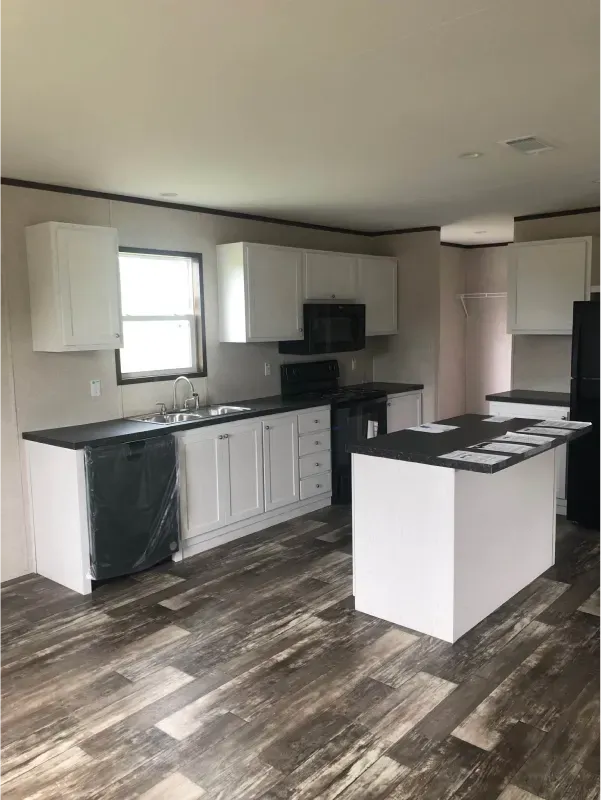A kitchen in a mobile home with a large island in the middle.
