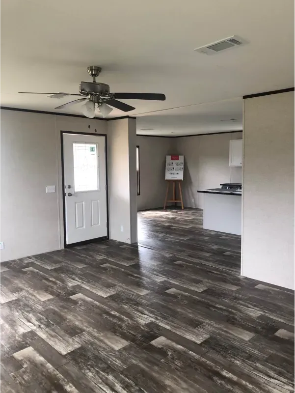 A living room with hardwood floors and a ceiling fan.
