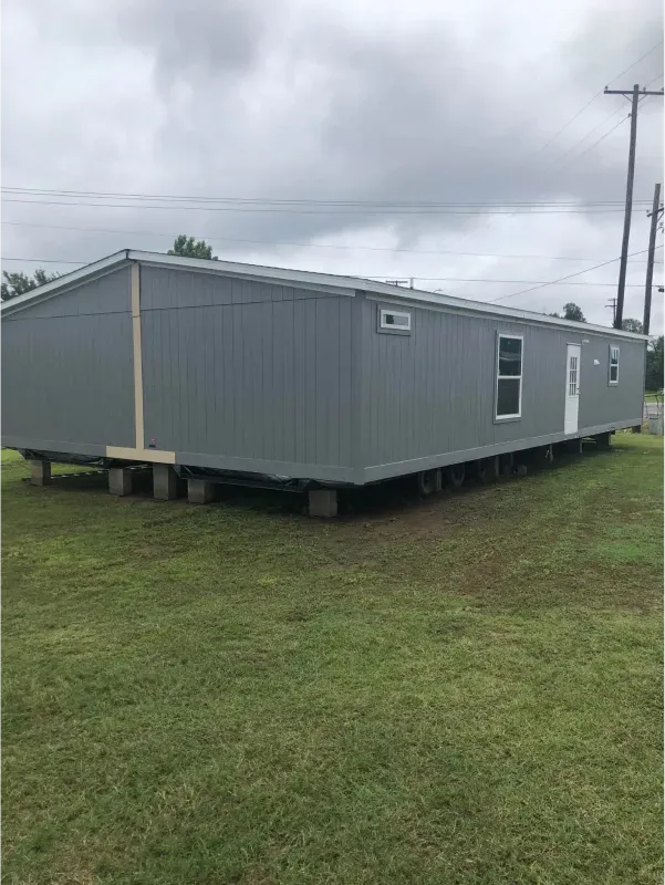 A mobile home is sitting on top of a lush green field.