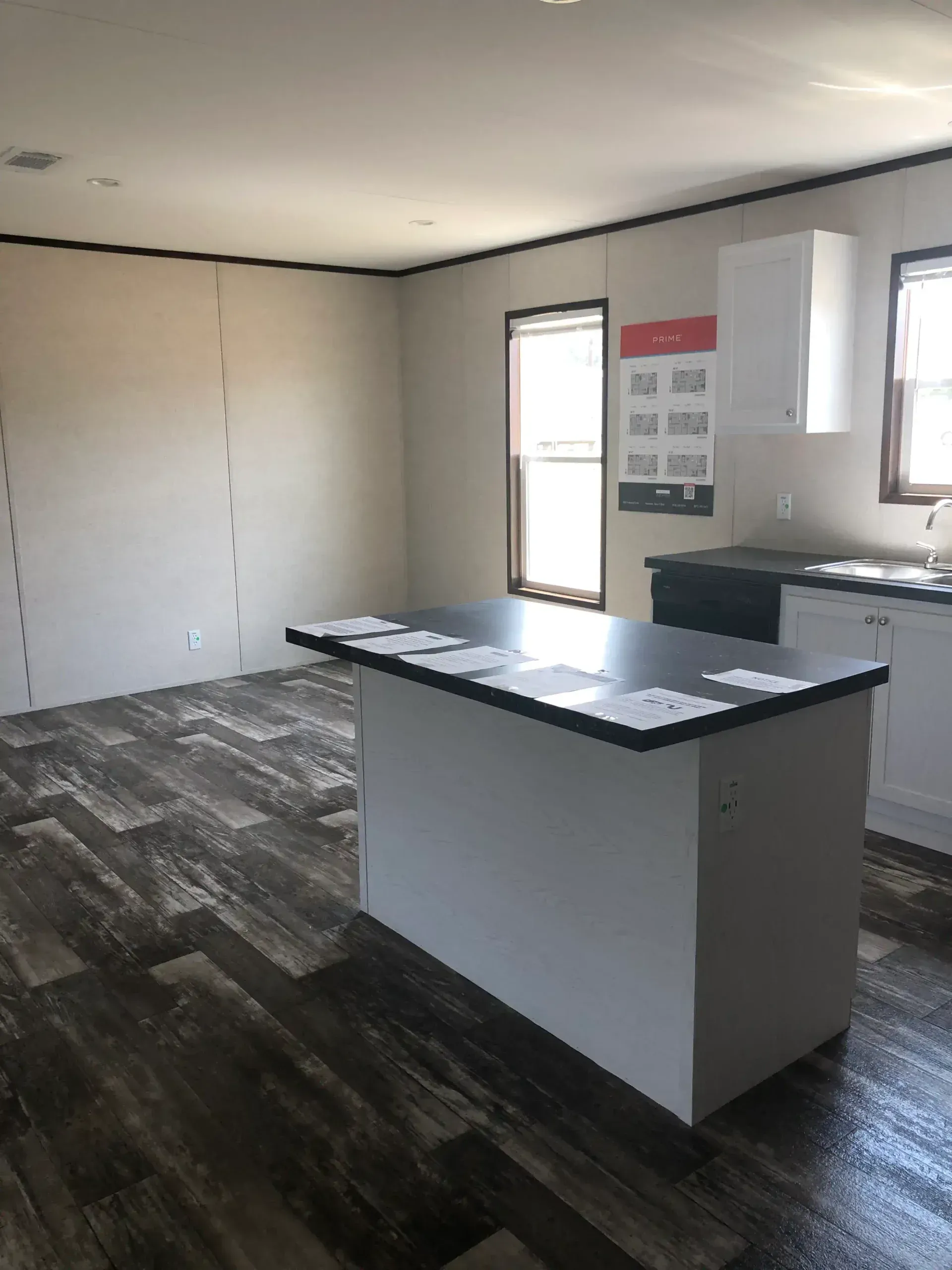 An empty kitchen with a large island in the middle