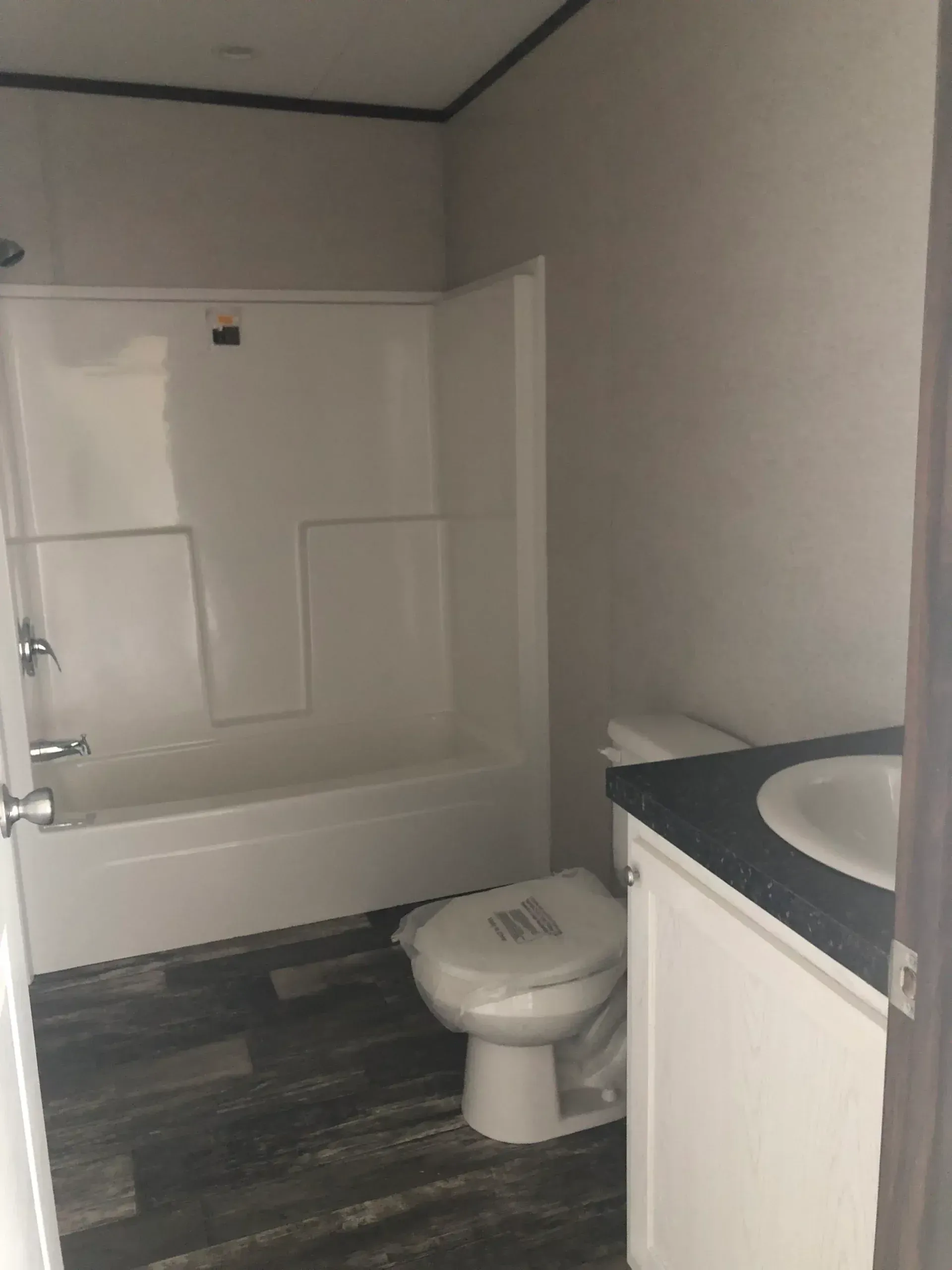 A bathroom with a toilet , sink , bathtub and shower.