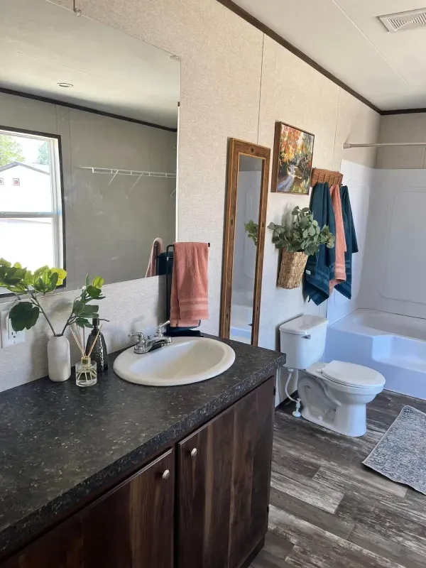 A bathroom with a sink , toilet , bathtub and mirror.
