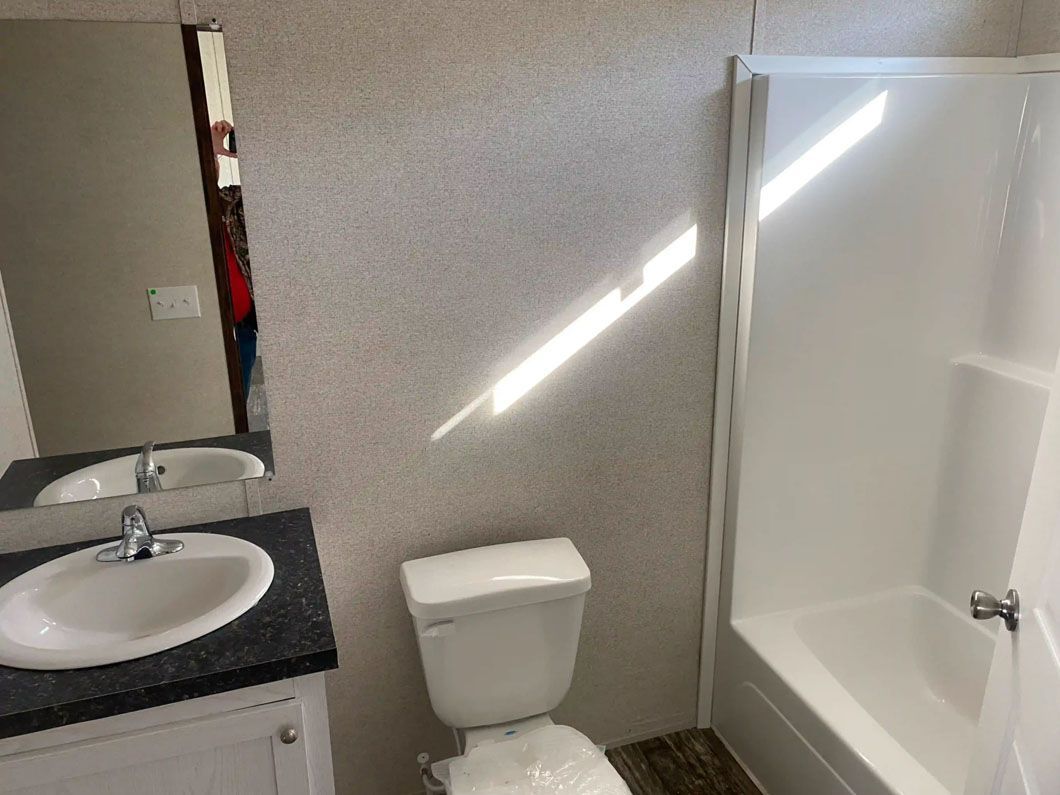 A bathroom with a toilet , sink , and shower.