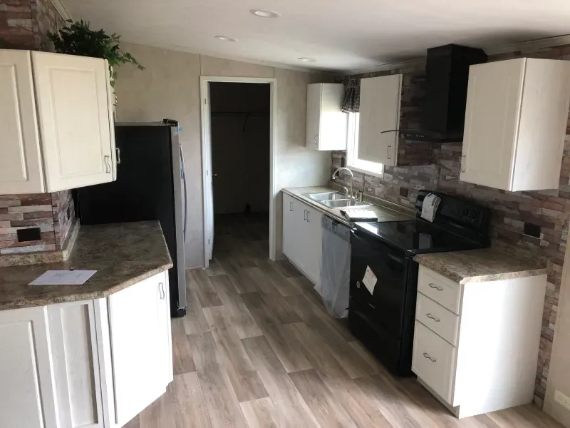 A kitchen with white cabinets and a black stove