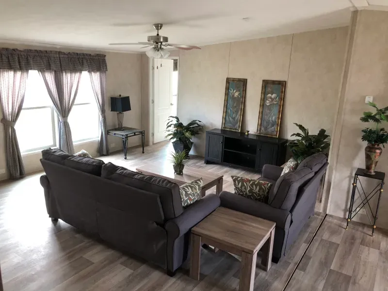 A living room filled with furniture and a ceiling fan.