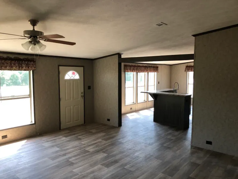 A living room with a ceiling fan and a door