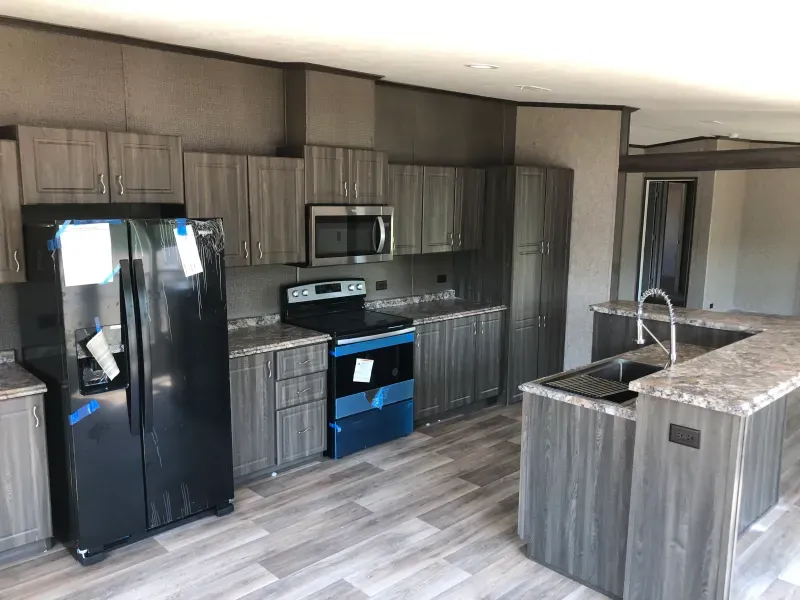 A kitchen with a refrigerator , stove , microwave and sink.