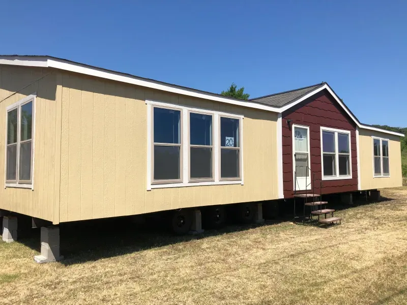 A mobile home is sitting in the middle of a field.