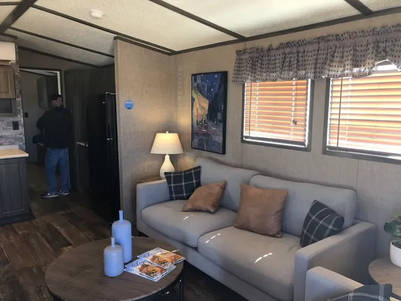 A living room in a mobile home with a couch and a table.