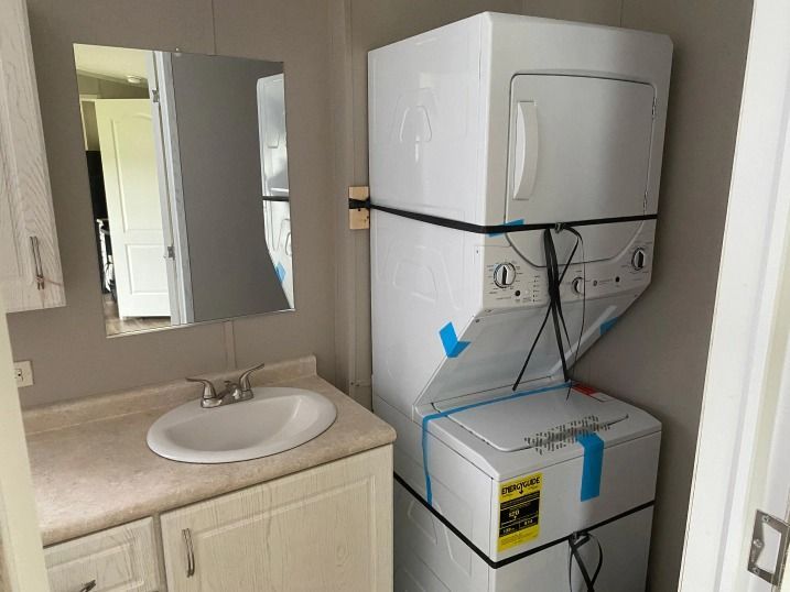 A bathroom with a washer and dryer stacked on top of each other.