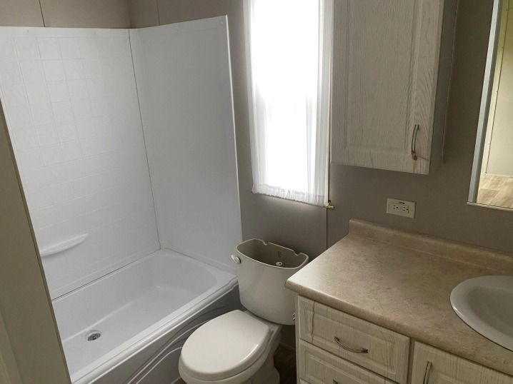 A bathroom with a toilet , sink and bathtub.
