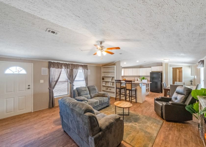 A living room filled with furniture and a ceiling fan.