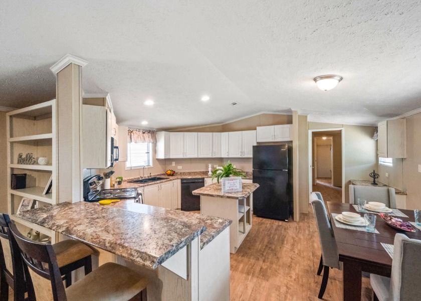 A kitchen and dining room in a mobile home with a table and chairs.