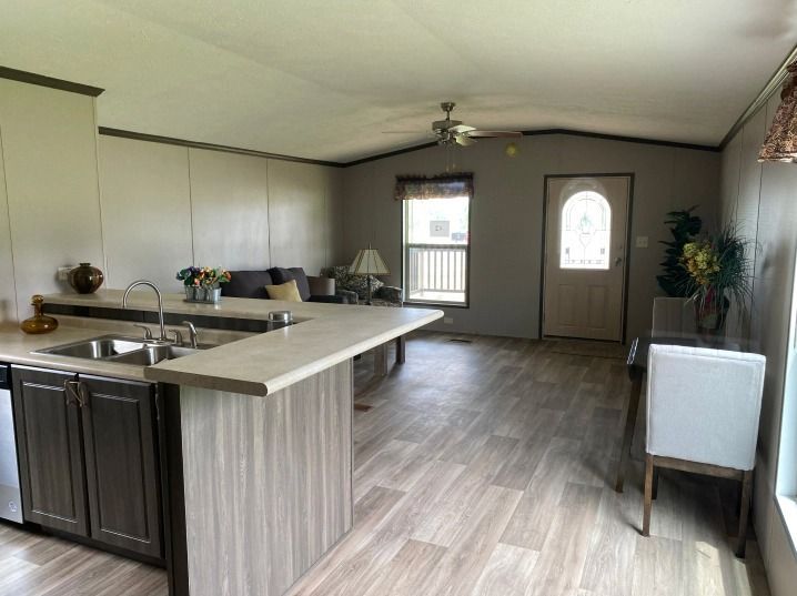 A kitchen in a mobile home with a sink and a dining table.