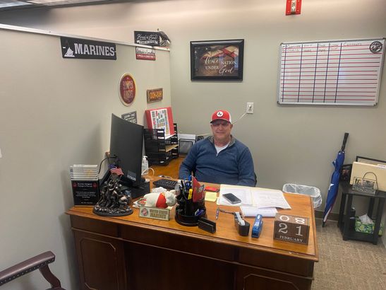 A man is sitting at a desk in an office.