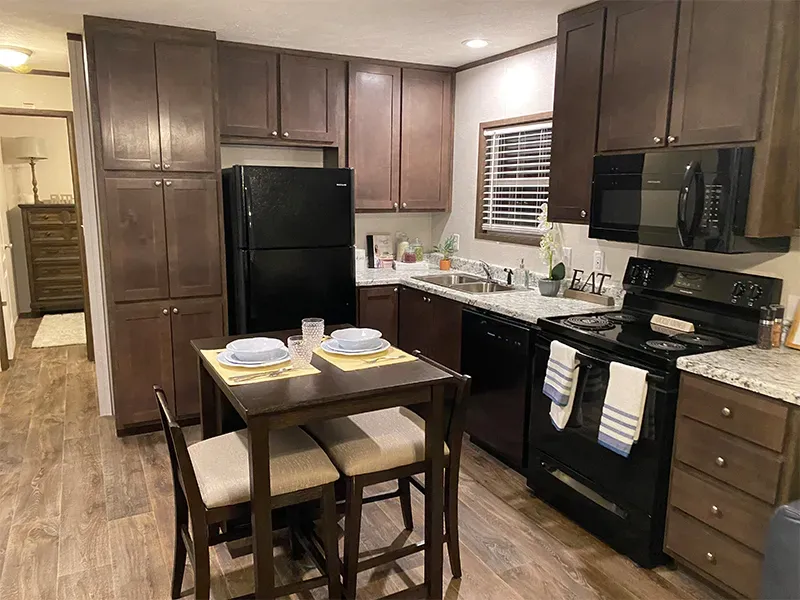 A kitchen with a table and chairs and a refrigerator.