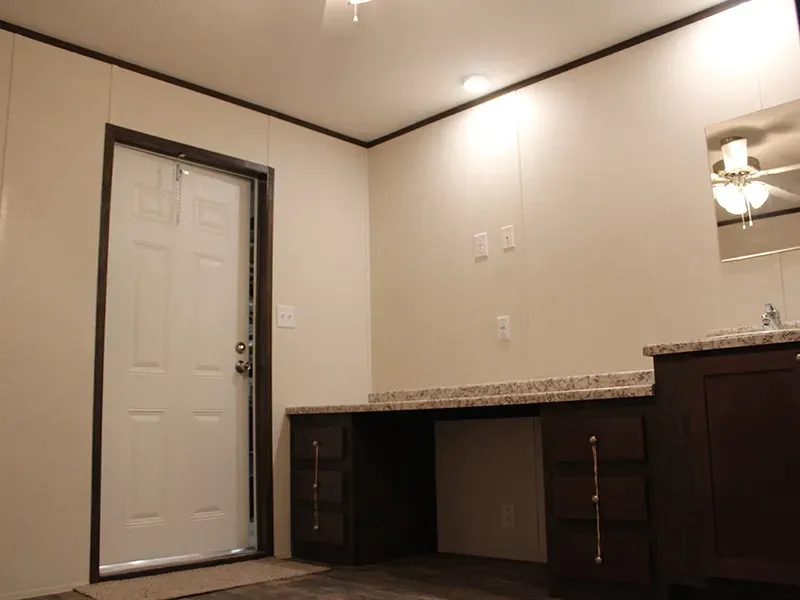 A bathroom with a sink and a mirror and a door