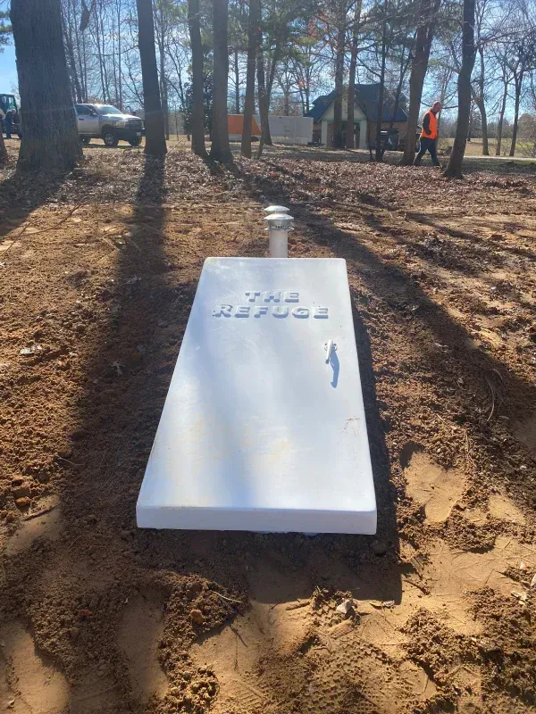 A white box is sitting in the middle of a dirt field.