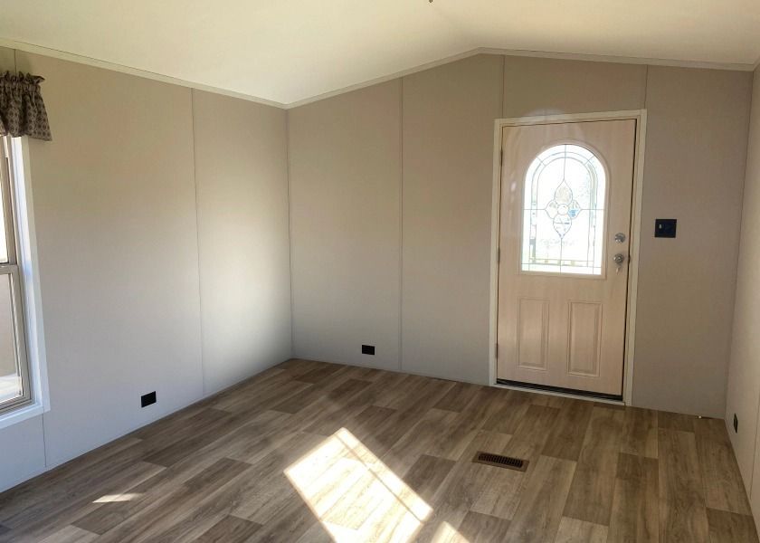 A living room in a mobile home with a door and window.