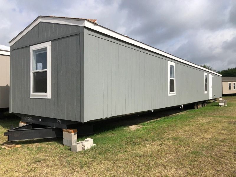 A mobile home is parked in a grassy field.