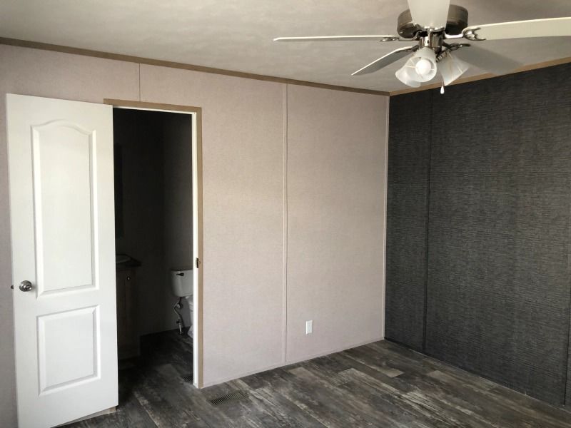 An empty room with a ceiling fan and a door