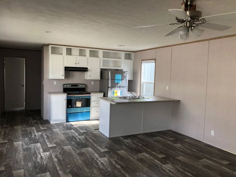 A kitchen with white cabinets and a ceiling fan
