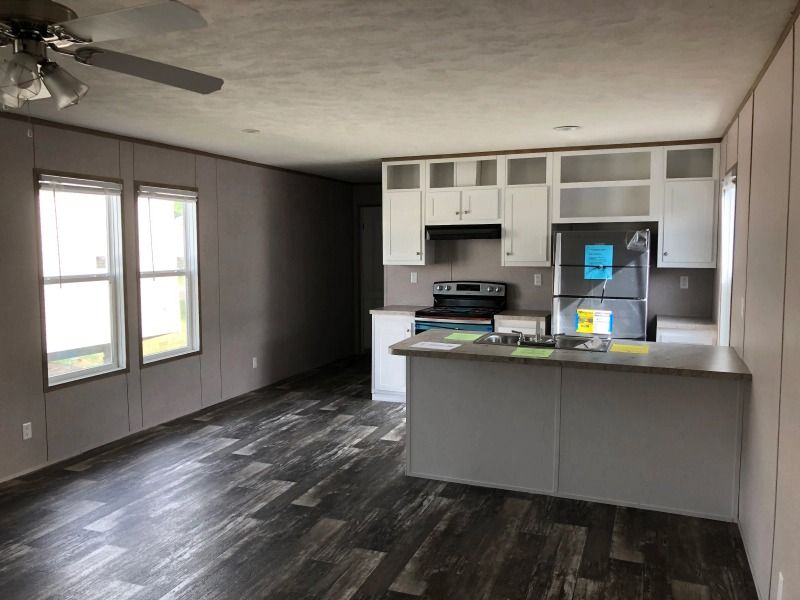 A kitchen in a mobile home with a ceiling fan.