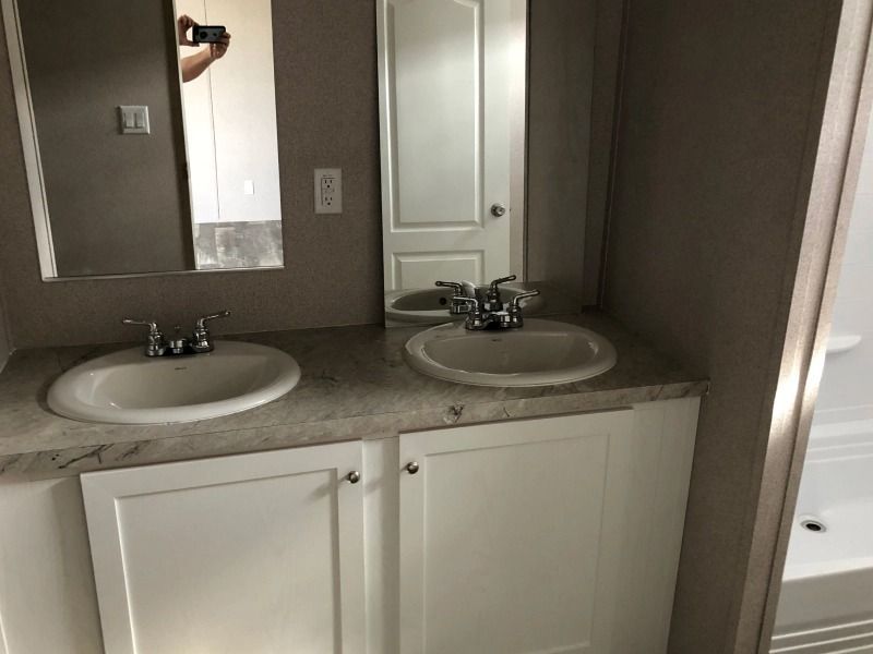 A bathroom with two sinks and a mirror