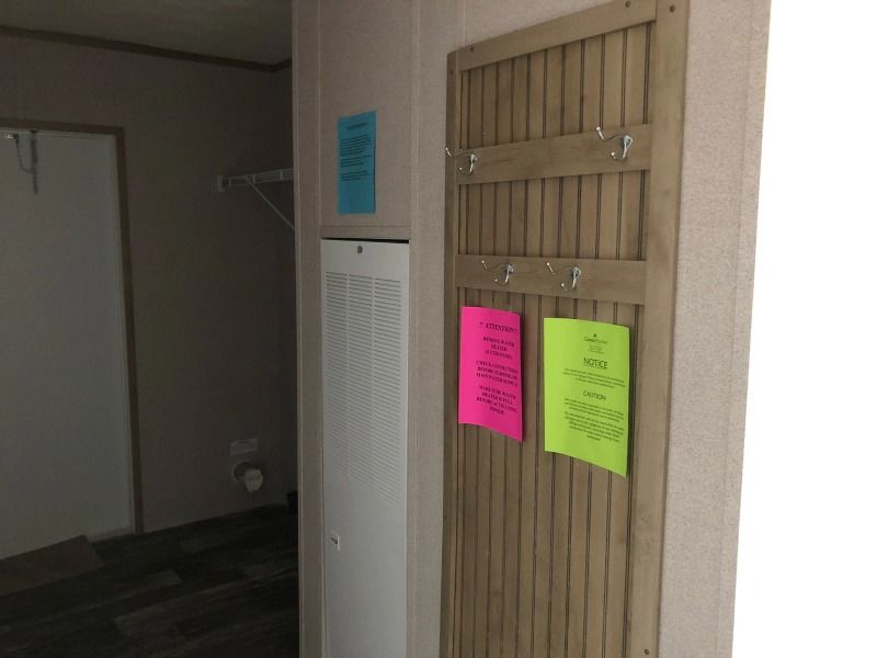 A wooden wall with a bunch of sticky notes hanging on it.