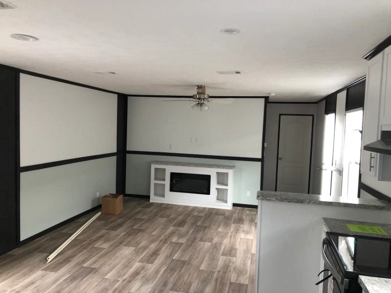 A living room with a fireplace and a ceiling fan.