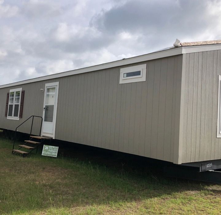 A mobile home is parked in a grassy field
