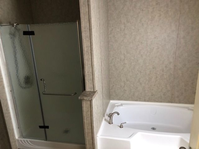 A bathroom with a bathtub and a shower stall.