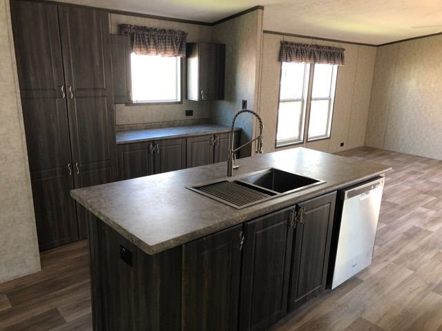 A kitchen with a large island and a sink.
