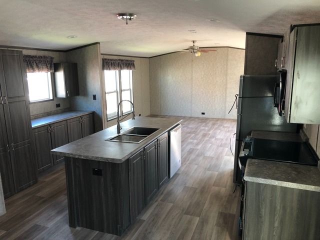 A kitchen in a mobile home with a large island in the middle.