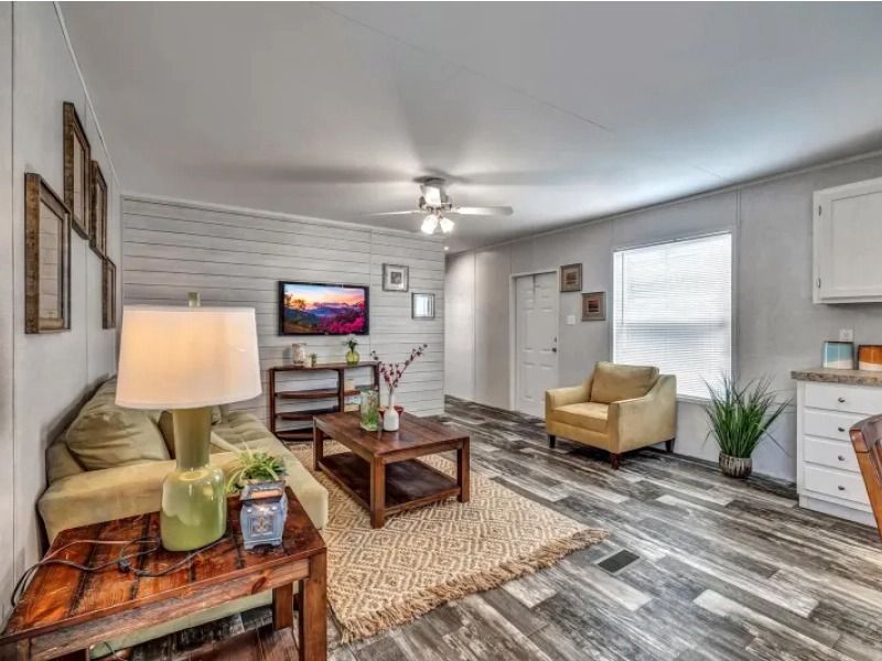 A living room with a couch , chairs , coffee table and television.