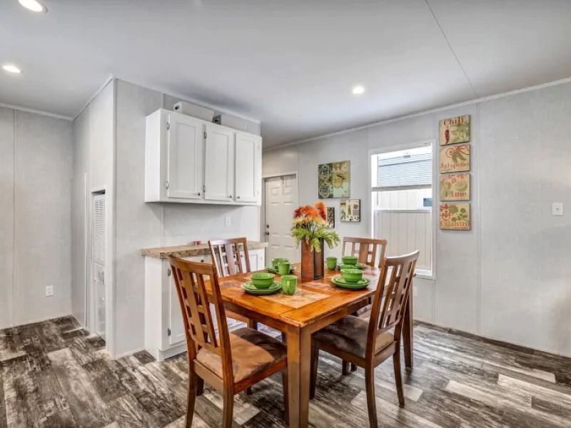 A dining room with a wooden table and chairs in a mobile home.