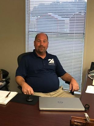 A man is sitting at a desk with an hp laptop