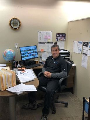 A man is sitting at a desk in front of a computer.